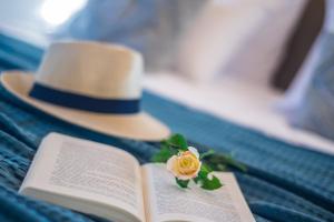 einen Hut und eine Blume auf einem offenen Buch in der Unterkunft Villa Milano in Laganas