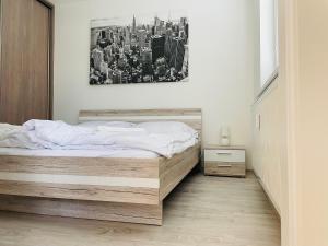 a bedroom with a bed and a picture of a city at SGL apartment Liptovska with free parking in Trenčín