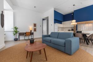 ein Wohnzimmer mit einem blauen Sofa und einem Tisch in der Unterkunft Ando Living - Abrantes 10 House in Lissabon