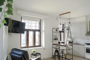 ein Wohnzimmer mit einem Tisch und einer Küche in der Unterkunft The Sunset - Top Floor Studio apartment in Pietarsaari