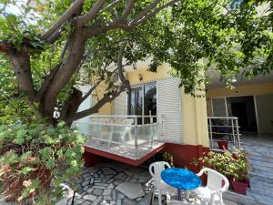 a patio with a table and chairs under a tree at Villa Eleni - Thassos Town in Limenas