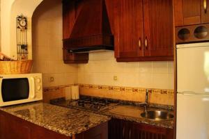 波索阿爾孔的住宿－Cortijo Aurelia，厨房配有木制橱柜和白色微波炉