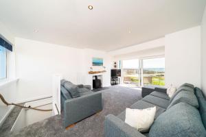 a living room with a blue couch and a large window at The Beach Boathouse in Carnoustie