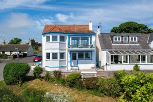 a large blue and white house with a porch at The Beach Boathouse in Carnoustie