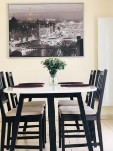 Beautiful Apartment near Geneva في سانت-جوليا-أون-جينيفوا: طاولة طعام مع كراسي و إناء من الزهور