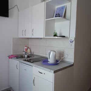 una cocina con armarios blancos y tostadora en una encimera en Apartmani Stanković en Podaca