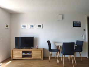 a living room with a tv and a table and chairs at Hengnau 46, Ferienwohnung Stiefel EG in Hengnau