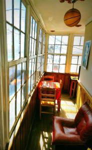 a living room with a table and chairs and windows at Colors House in Sucre