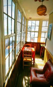 een woonkamer met een tafel, stoelen en ramen bij Colors House in Sucre