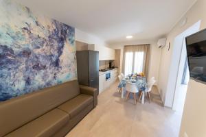sala de estar con sofá y mesa con sillas en Alta Marea Sea Apartments, en Balestrate