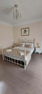 Schlafzimmer mit einem weißen Bett und einem Kronleuchter in der Unterkunft Cozy Central Apartment in Inverness