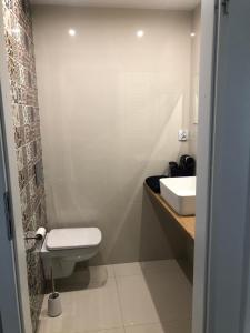 La salle de bains est pourvue de toilettes blanches et d'un lavabo. dans l'établissement Apartment Tarasy centrum, à Siemiatycze