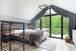 a bedroom with a bed and a large window at NOVA ULINIA Forest - dom nad morzem, podgrzewany basen , sauna, balia z jacuzzi, Starlink in Ulinia +56 photos