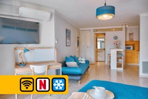 a living room with a blue couch and a table at Grand Studio Cannes Centre in Cannes