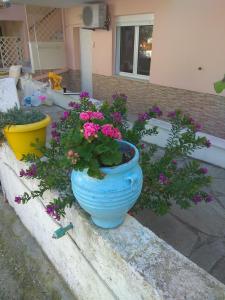 un jarrón azul lleno de flores rosas en una cornisa en Filomeni Studios, en Pefkohori