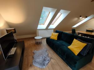 a living room with a green couch with yellow pillows at Apartament Góry Bardzkie in Bardo