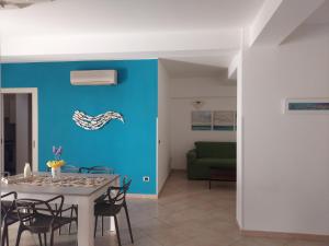 jadalnia z niebieską ścianą i stołem w obiekcie Villa Costanza Casa Vacanze w mieście Avola