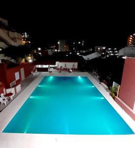 a blue swimming pool on top of a building at night at Intersur Villa Gesell in Villa Gesell