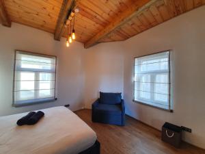 - une chambre avec un lit et une chaise bleue dans l'établissement KK Apartment, à Ventspils