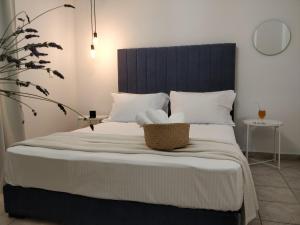 a bed with a blue headboard and white pillows at Afytos Sivilla in Afitos