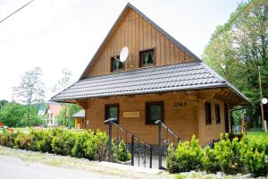 ein kleines Holzhaus mit einem Gamer-Dach in der Unterkunft Chata Nezábudka in Oščadnica