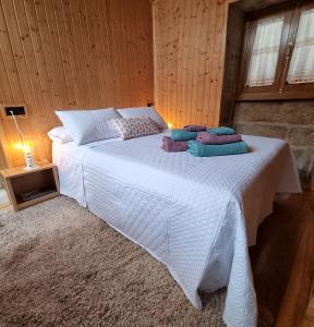 Un dormitorio con una cama blanca con almohadas. en Casa mariñeira San Tomé, en Cambados
