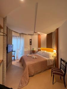 a bedroom with a bed and a tv and a chair at Sinestesia in Polignano a Mare