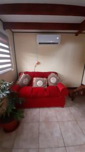 a red couch in the corner of a room at Cabaña Punto Punahue in Choshuenco