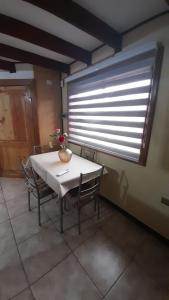 Cabaña Punto Punahue في تشوشوينكو: طاولة وكراسي في غرفة مع نافذة كبيرة