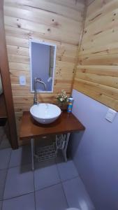 a bathroom with a sink in a wooden wall at Cabaña Punto Punahue in Choshuenco