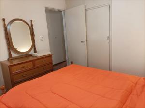 a bedroom with a bed and a mirror and a dresser at Hermoso departamento en Mendoza in Mendoza