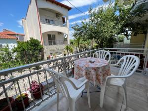 a table and chairs on a balcony with a building at Villa Eleni - Thassos Town in Limenas