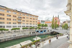 een brug over een rivier in een stad met gebouwen bij AB Ljubljana - Prince Filip Apartment in Ljubljana