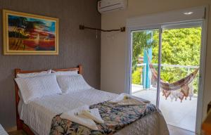 a bedroom with a bed and a sliding glass door at Residencial Águas de Bare in São Sebastião +117 photos