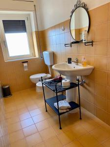 ein Bad mit einem Waschbecken und einem WC in der Unterkunft Casa Marinella al confine fra Basilicata e Puglia in Bernalda