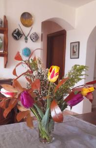 un jarrón de cristal lleno de flores de colores en una mesa en In Vino Veritas en Arcola