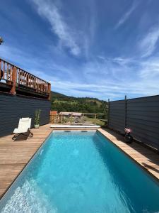 una piscina con terrazza in legno di Le chalet de cathy a Soultzeren