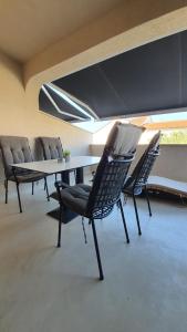 a dining room with chairs and a table and a window at Apartments Gemma in Mandre