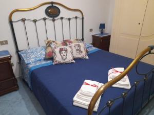 1 dormitorio con 1 cama con sábanas y almohadas azules en Casa Holiday, en Caccamo