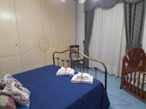 um quarto com uma cama azul com toalhas em Casa Holiday em Caccamo