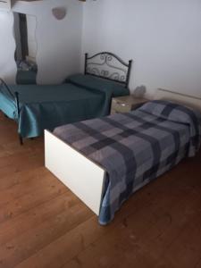 1 dormitorio con 2 camas y manta a cuadros en Appartamento accogliente/nuovo Livorno en Livorno