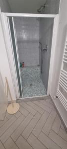 y baño con ducha y suelo de baldosa. en Appartamento accogliente/nuovo Livorno en Livorno