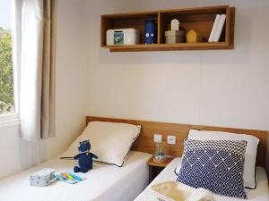 un osito de peluche pequeño sentado en una cama en una habitación en Chalet op Camping Lauwersoog met 3 slaapkamers en vaatwasser - JoyCasa, en Lauwersoog