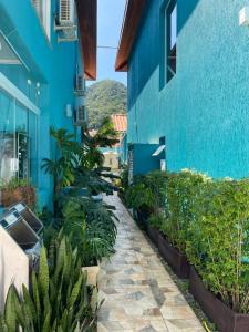 un edificio azul con un patio con plantas en Residencial Águas de Bare en São Sebastião