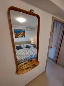 a mirror on a wall with a bed in a room at Apartment Sonia in Ičići