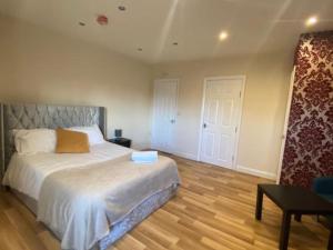 um quarto com uma cama grande e piso em madeira em Roundhay Apartments em Leeds