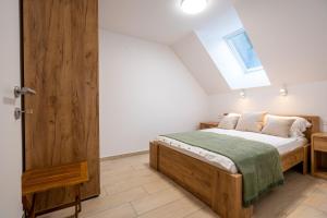 a bedroom with a bed and a wooden door at Na-Ture Apartments in Zgornje Gorje