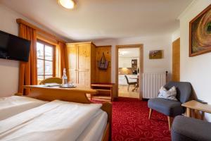 a hotel room with a bed and a desk and a chair at Pension Antonia in Fuschl am See