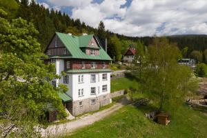 um grande edifício branco com um telhado verde em Astoria Inn em Spindleruv Mlyn