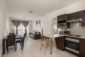 una cucina e un soggiorno con tavolo e sedie di V&S Apartments - Immaculate Luxury Apartment in Fourways, Johannesburg a Fourways